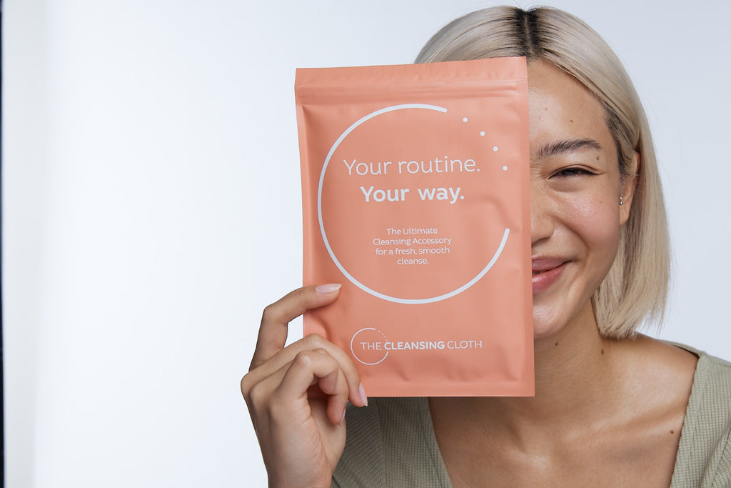 Model  holding up Cleansing Cloth packet to face