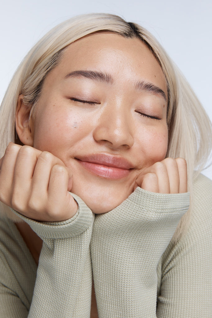 Close up model smiling with closed eye and clean glowy skin