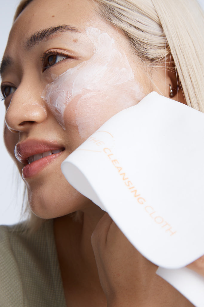 Close up model wiping cleanser from cheek with cleansing cloth