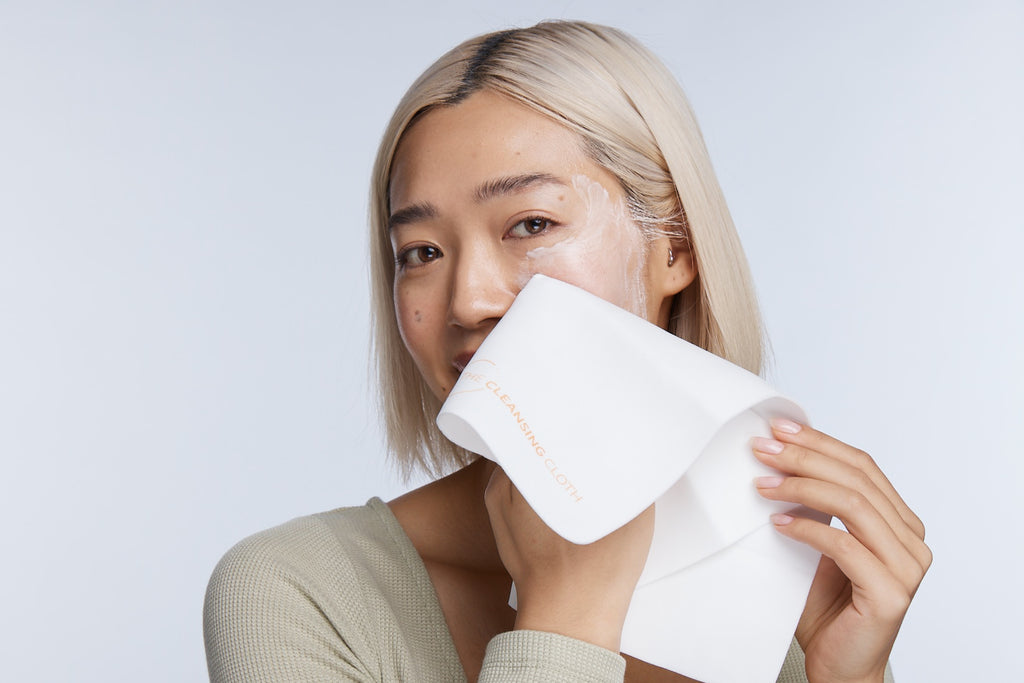 Model wiping cleanser from cheek with cleansing cloth